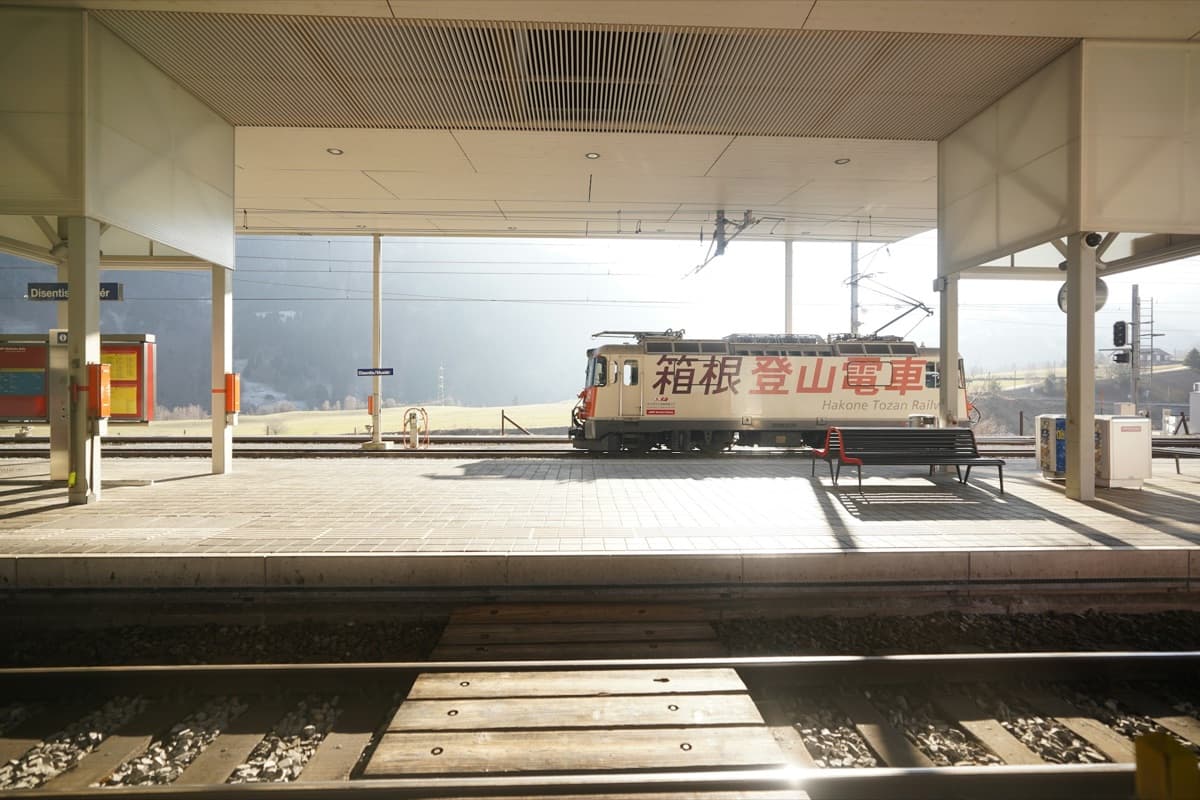A red and white Hakone Tozan Railway car standing at a station platform