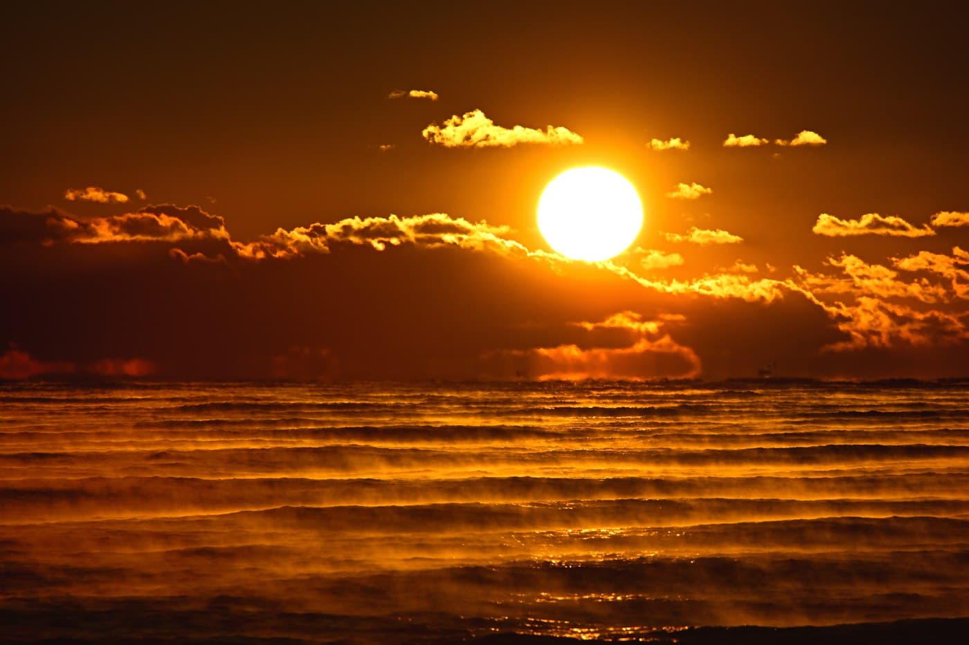 The first sunrise of the year rising over the sea, the water and clouds lit gold