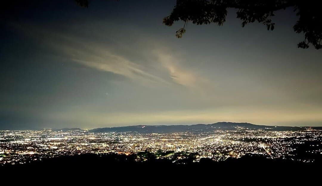 The lights of Nara city spread across the basin at night, seen from Mount Wakakusa