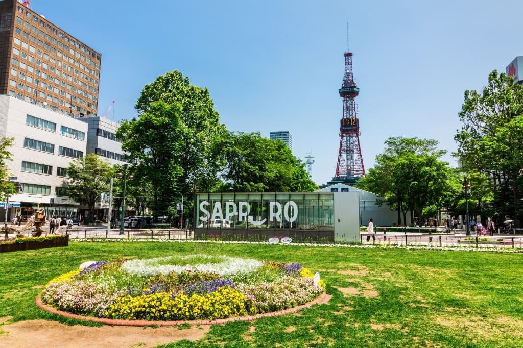Odori Park in central Sapporo with flower beds and the Sapporo TV Tower on a clear summer day