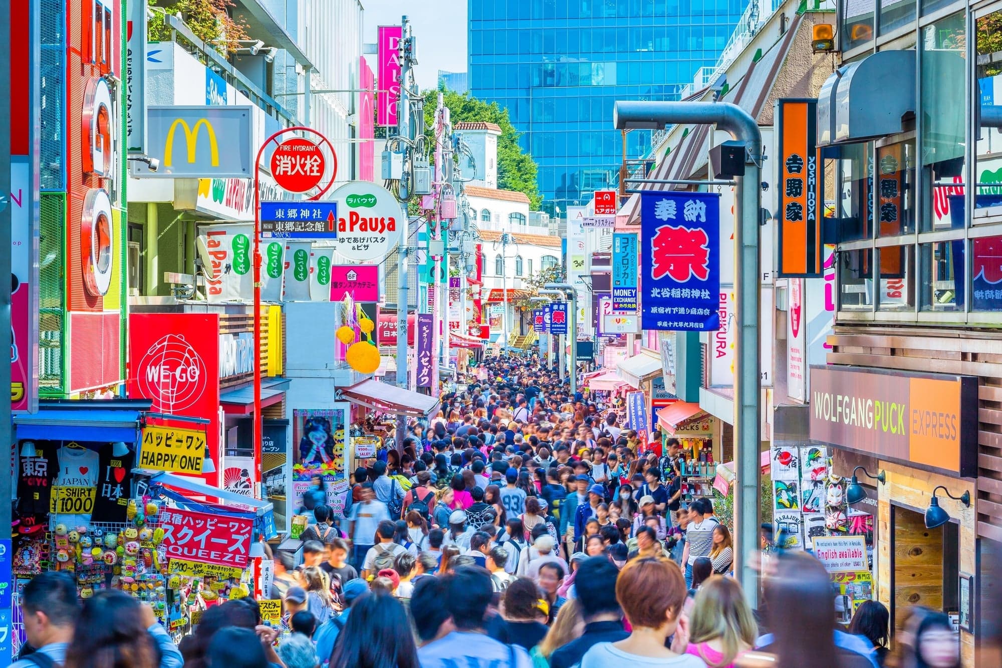 Crowds of shoppers filling Takeshita Street in Harajuku under colorful signs