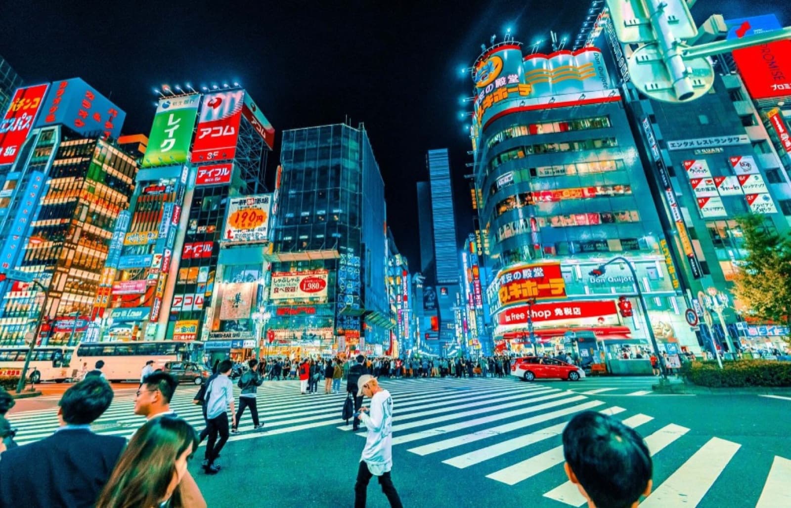 Crowds crossing a neon-lit street in Shinjuku's Kabukicho nightlife district at night, Tokyo